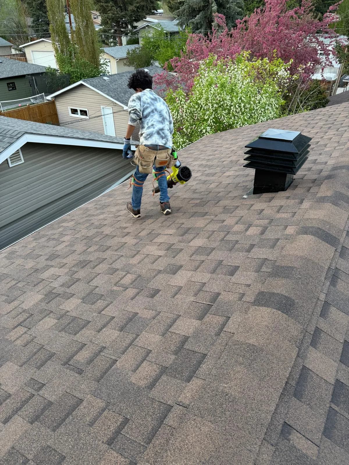 Roofer walking on new brown architectural shingles