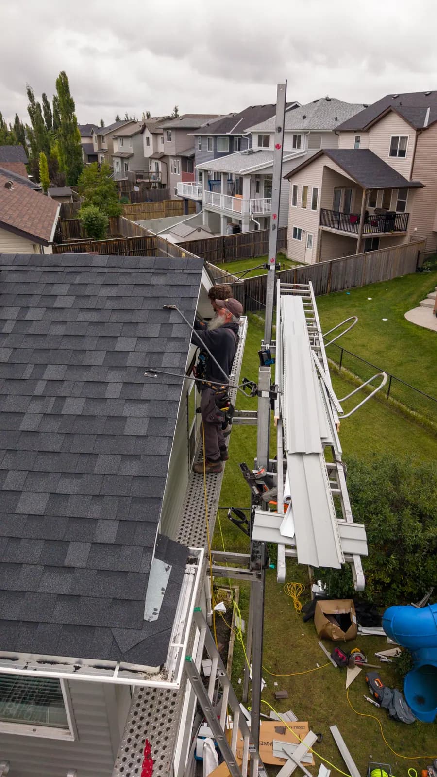 Crew working along the eave of a two-storey house