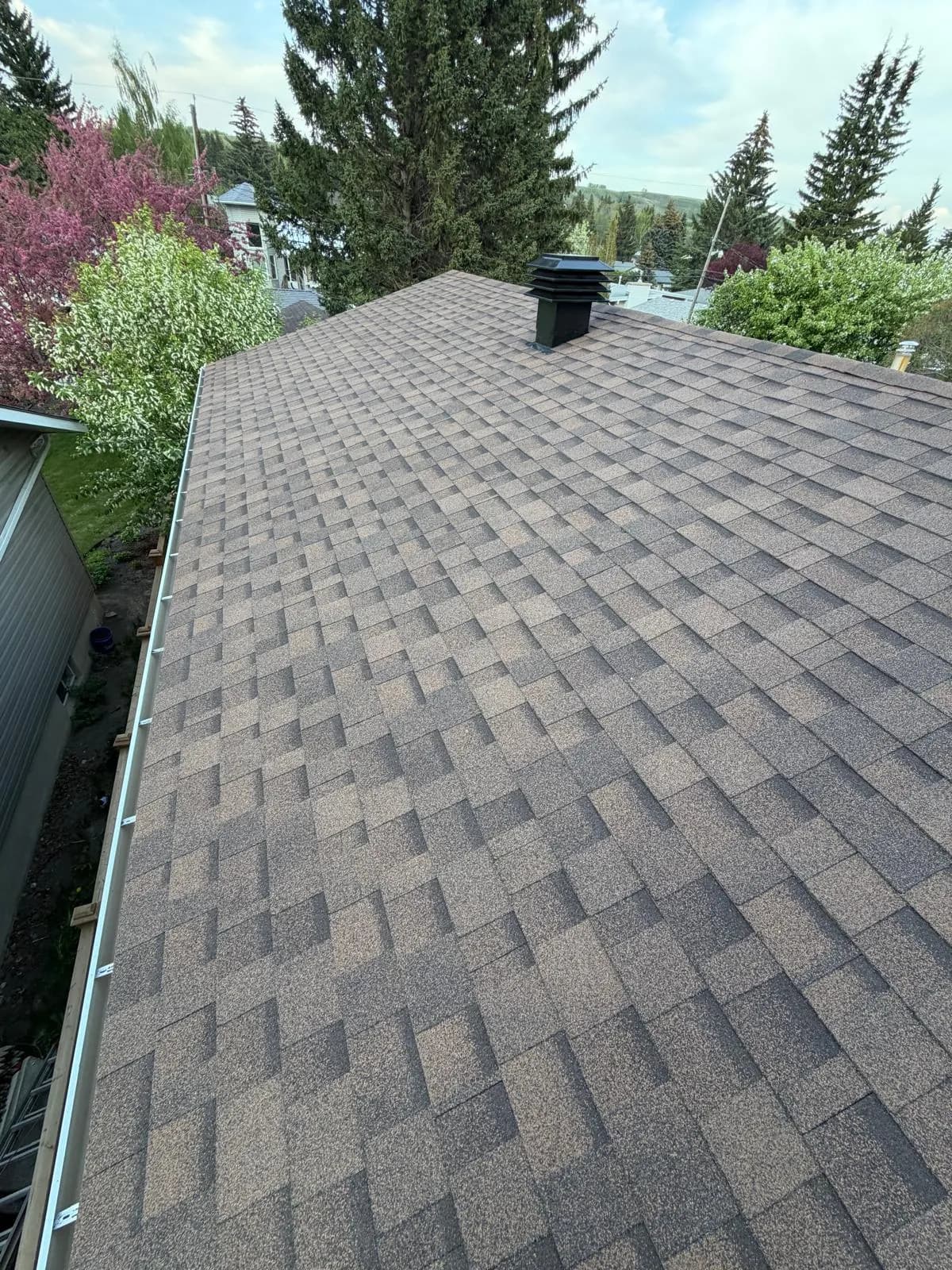 Roof edge with new shingles and an eavestrough