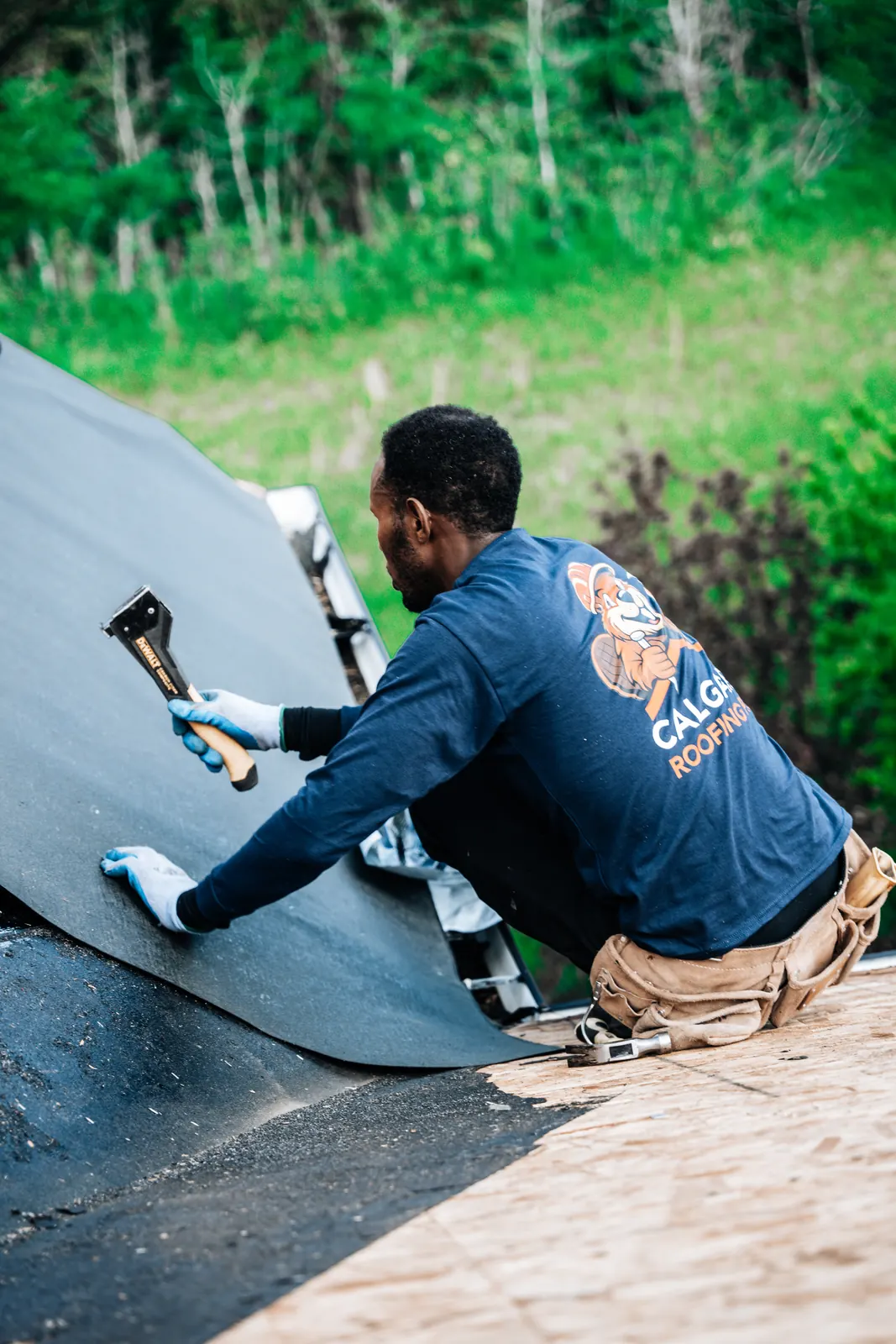 Calgary Roofing Pro crew member sealing membrane at the roof edge